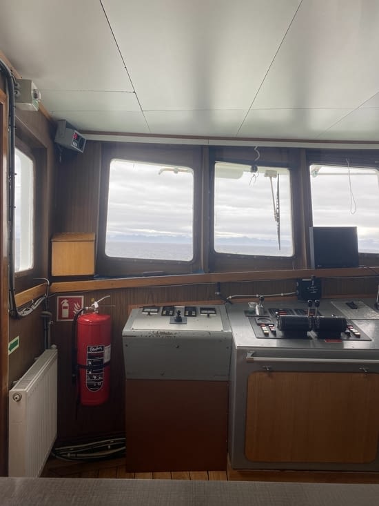 Depuis la cabine de pilotage, on voit au loin d’intrigantes montagnes