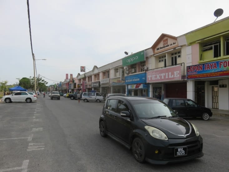 Ville classique Malaisienne. Une route, des commerces avec stationnement, et derriere, une maison pour chaque magasin ou habitent les vendeurs/proprios.