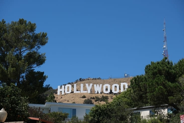 Dans les rues sinueuses, on aperçoit Hollywood Sign, entre 2 maisons gigantesques