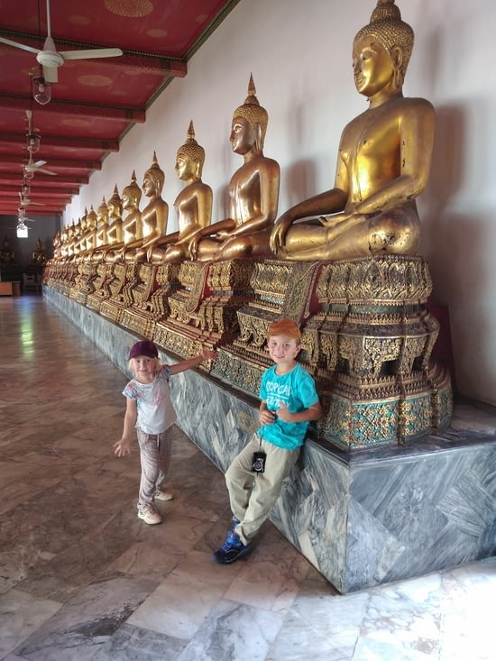 Les enfants contents de se balader parmi tous les bouddhas