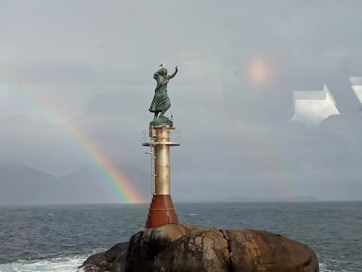 L'arc en ciel illumine la statue de la femme de pêcheur