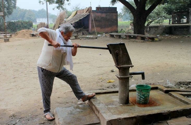 Monique actionne la pompe du village
