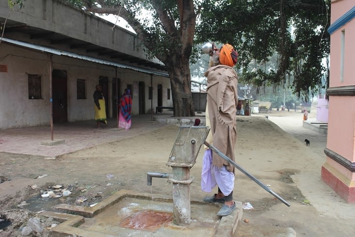 Un passant s'abreuve à la pompe