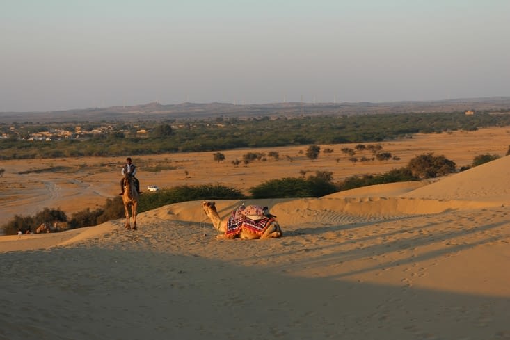 un chameau se repose en attendant de redescendre les touristes