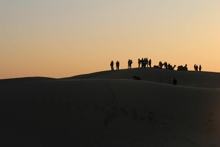 sur la dune la plus haute, une poignée de touristes