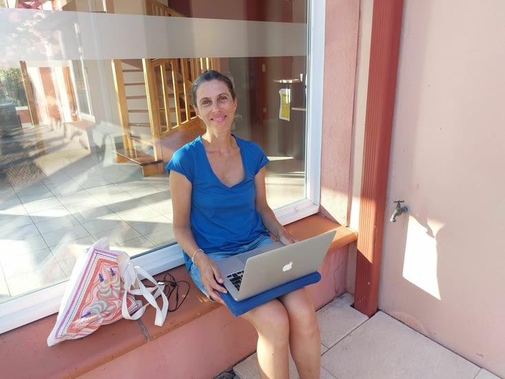 Véronique cherche du réseau à côté de l'accueil du camping.