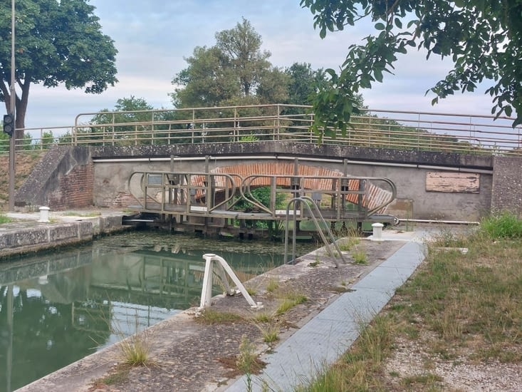 Une écluse devant un pont.