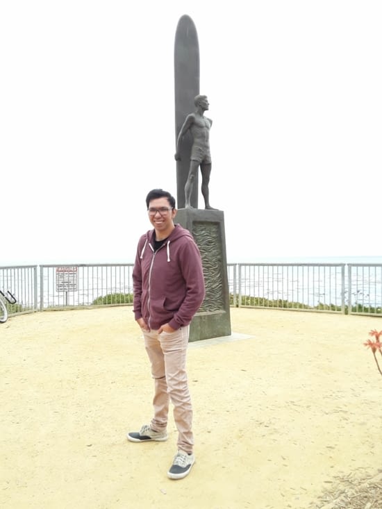 Sébastien le surfeur de la famille devant la statue