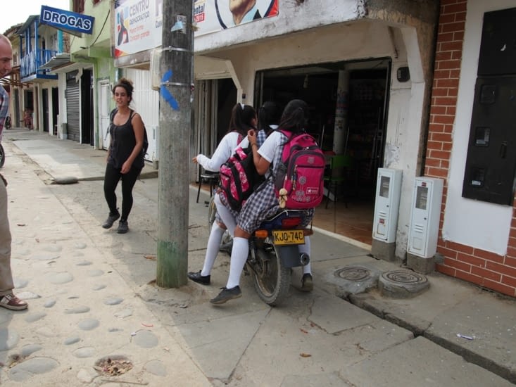 En traversant un village, on croise des ecoliers, á trois sur un scooter, un classique ici !
