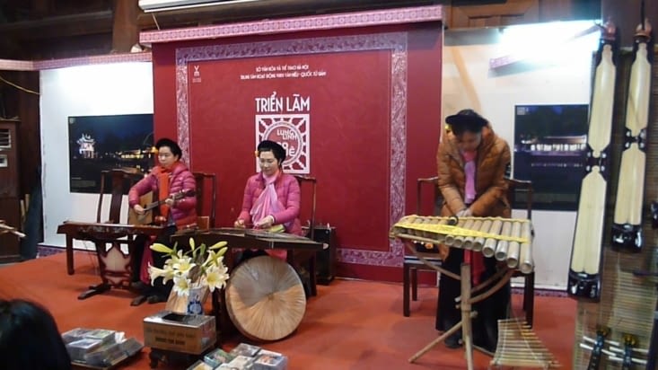 Musique vietnamienne au temple, la dame à droite tape dans ses mains devant des bambous