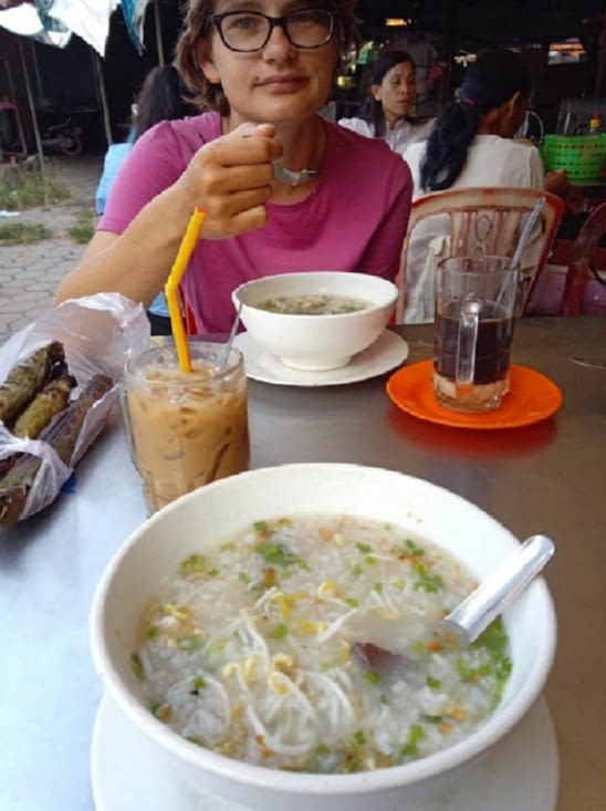 Petit déjeuner au marché: café froid et porridge de riz agrémenté d'herbes et de viande