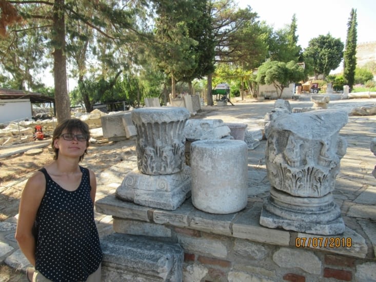 Alex pose à côté des restes de chapiteaux de colonnes
