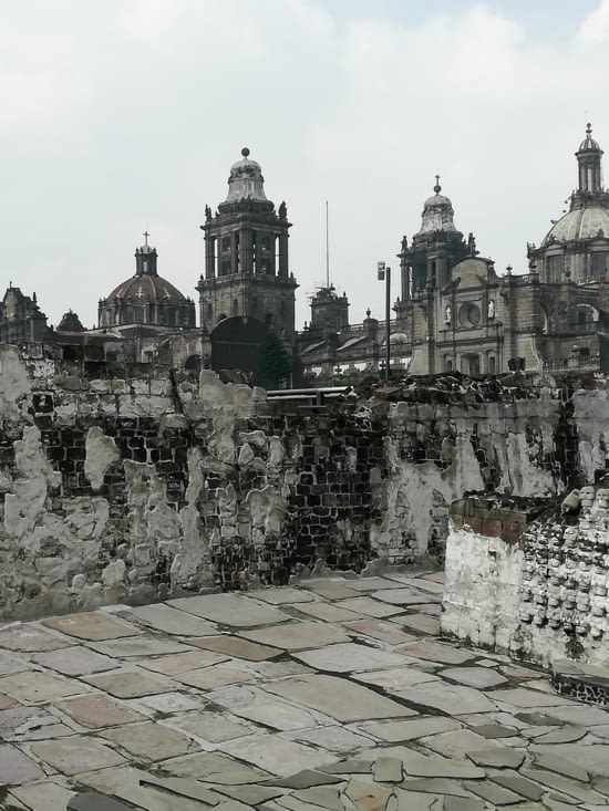 Vestiges du temple, crânes décoratifs en bas a droite et cathédrale a l'arrière
