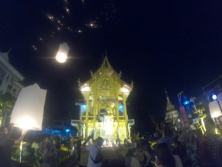 Lâché de lanternes devant un temple bouddhiste