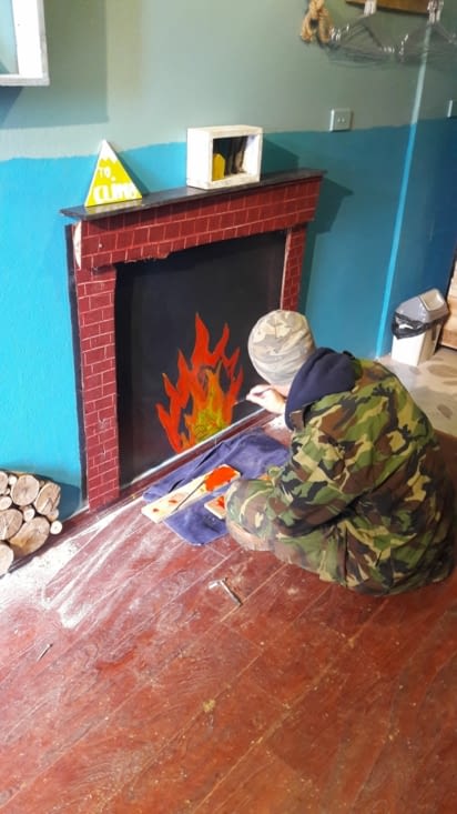 Clément dessinant un feu en habit de militaire