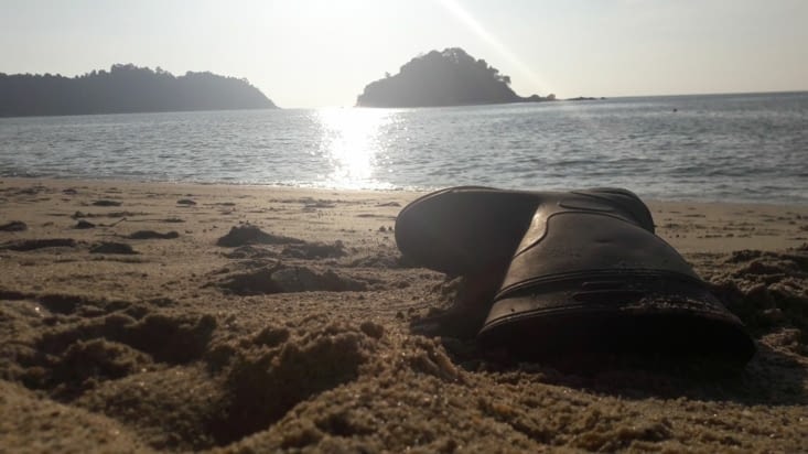 La subtile beauté d'une botte abandonnée sur une plage au couché du soleil