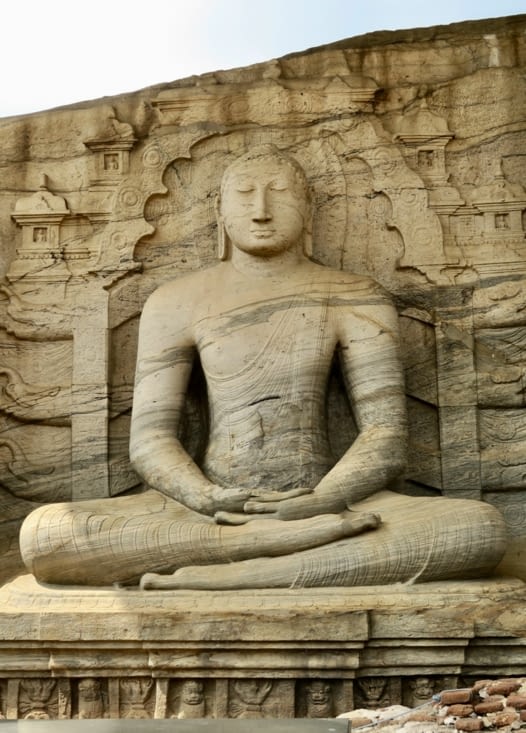 Le premier Bouddha, assis, a une expression de grande sérénité.