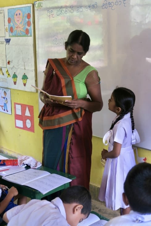La maîtresse commente les exercices.