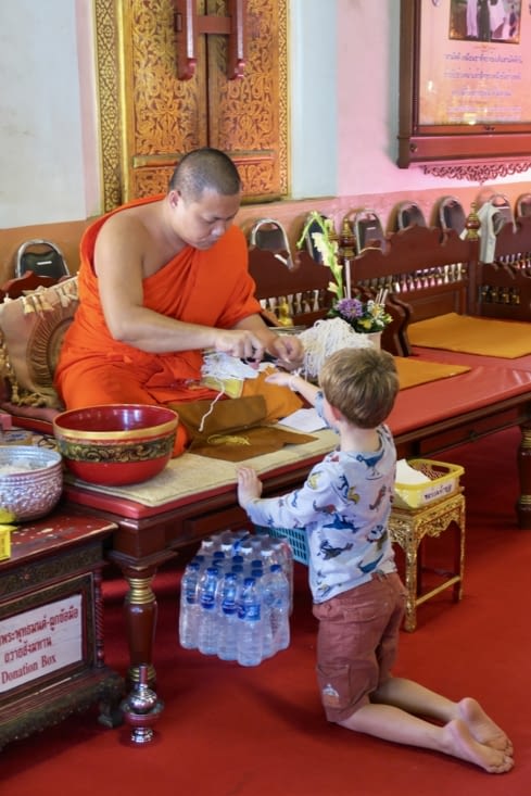Nous avons fait une offrande et un moine offre un bracelet de fil blanc à Maël.