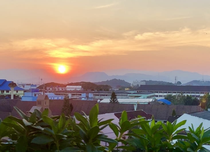 Au soleil couchant, les montagnes qui entourent la ville ressortent à l’horizon.
