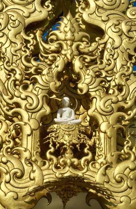 Un petit Bouddha blanc dans un écrin doré.