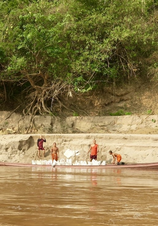 Des novices qui ramassent du sable de la berge.