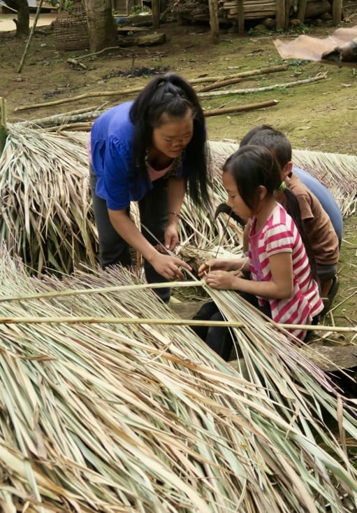 Ici, ils réalisent des portions de toit avec de grandes herbes sèches.