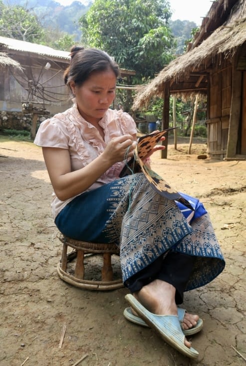 Sa fille brode une petite pochette qui sera vendue sur le marché de nuit de Luang Prabang.