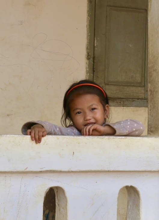 Une petite tête qui dépasse d’un muret de l’école.