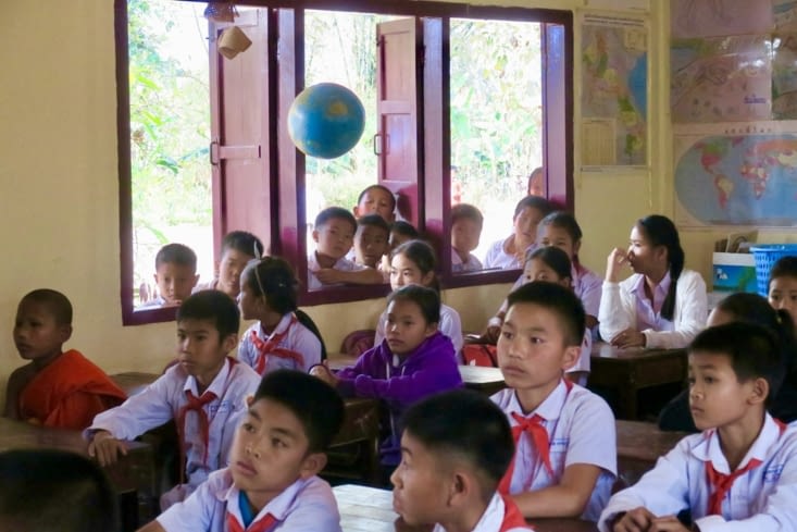 Aux fenêtres, des spectateurs qui ont quitté leur classe...
