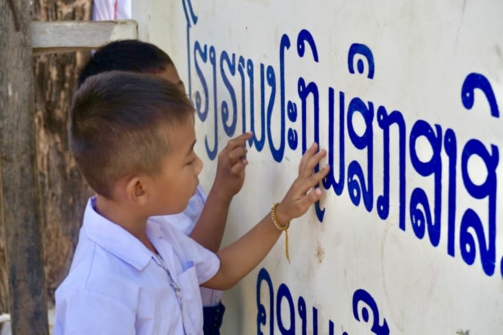 ... ils s’entraînent à suivre les lettres sur le nom de l’école.