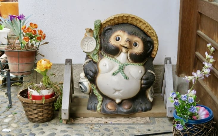 Très souvent, près de la porte des maisons, une petite sculpture veille.