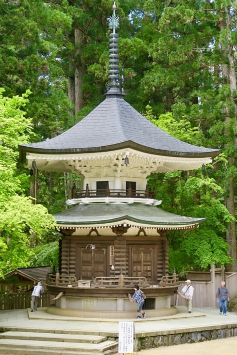 Trois pèlerins font tourner un étage de cette petite pagode.