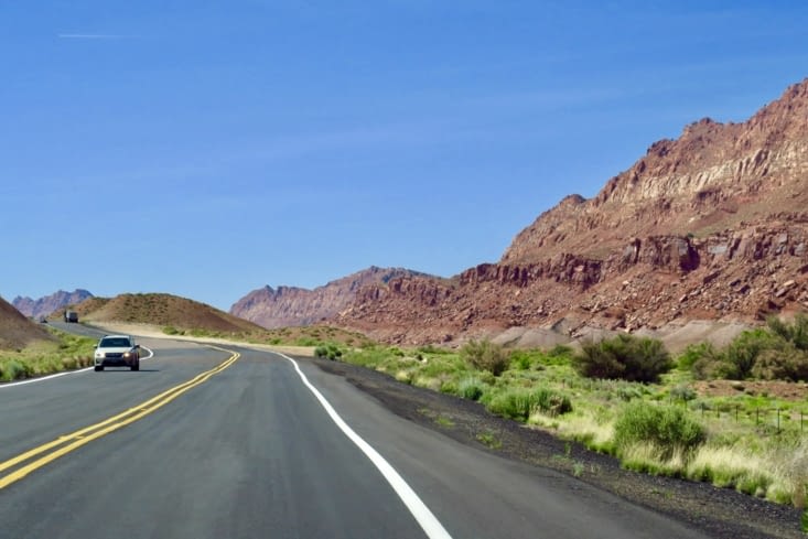 ... la route est bordée de roches ocre rouge.
