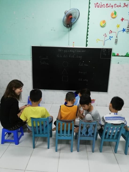 Sarah écoute la maîtresse avec les enfants