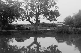 Voiture. Gens dormant dans une tente au bord du canal.
