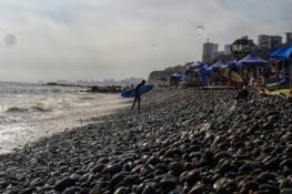Surfeur de Lima sur sa plage de galets